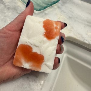 Hand holding Moonlit Jasmine Elixir Soap, showcasing top pattern.