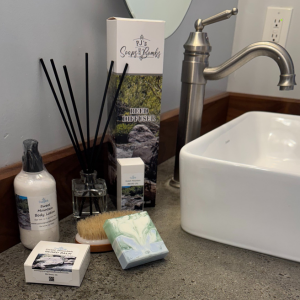 Mountain Escape Handcrafted Soap, Lotion, Beard Oil, Beard Balm, and Reed Diffuser in a rustic bathroom setting