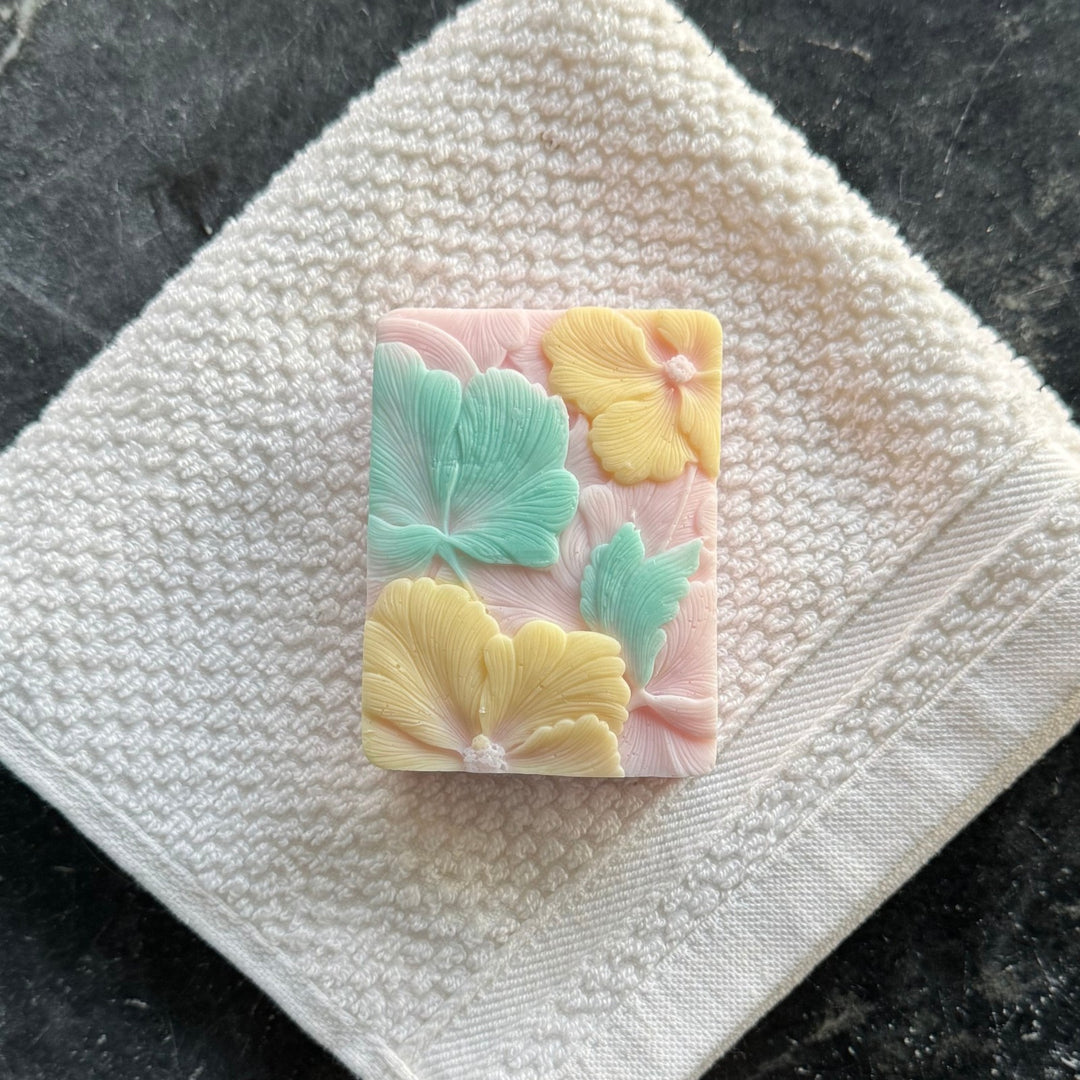 Pink Plumeria Soap showcasing top pattern with yellow flowers and green leaves