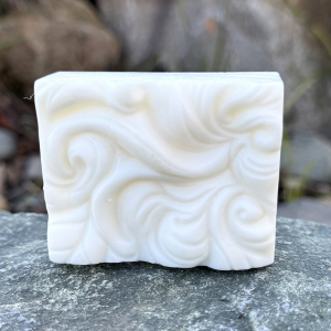 Simply White soap sitting  on a rock