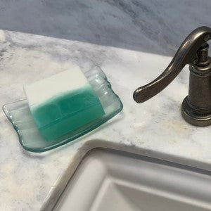 Cedar Mist Soap sitting on a soap dish in a  bathroom setting