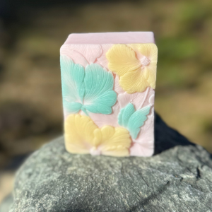 Pink Plumeria Soap, front of soap standing up on rock natural setting