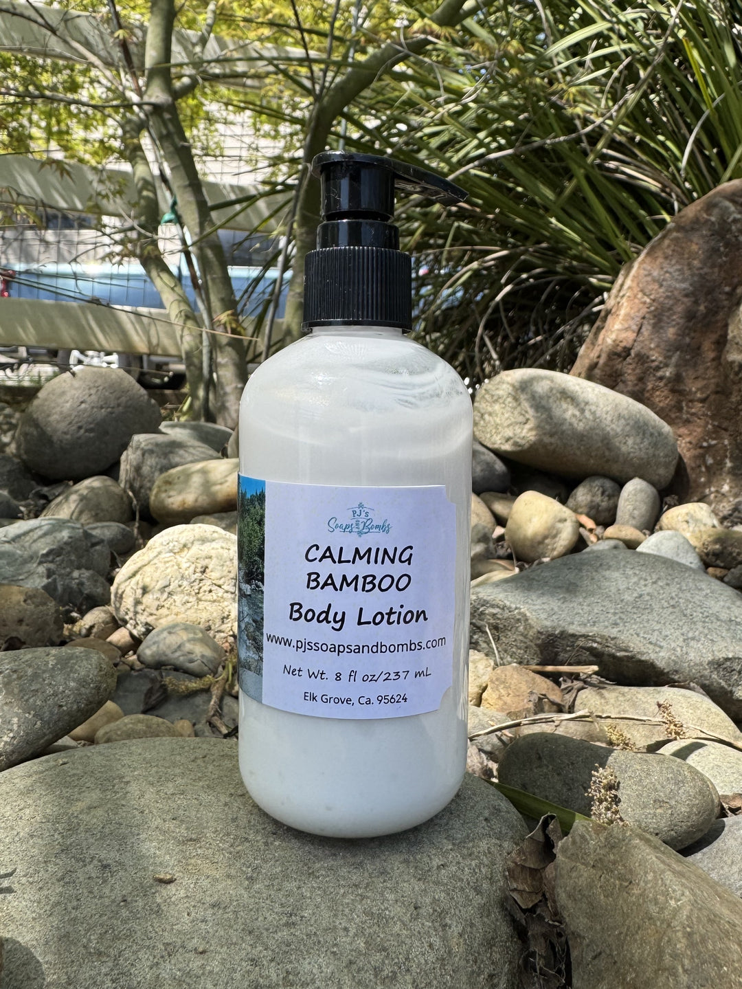Calming Bamboo Body Lotion in natural setting sitting on a rock