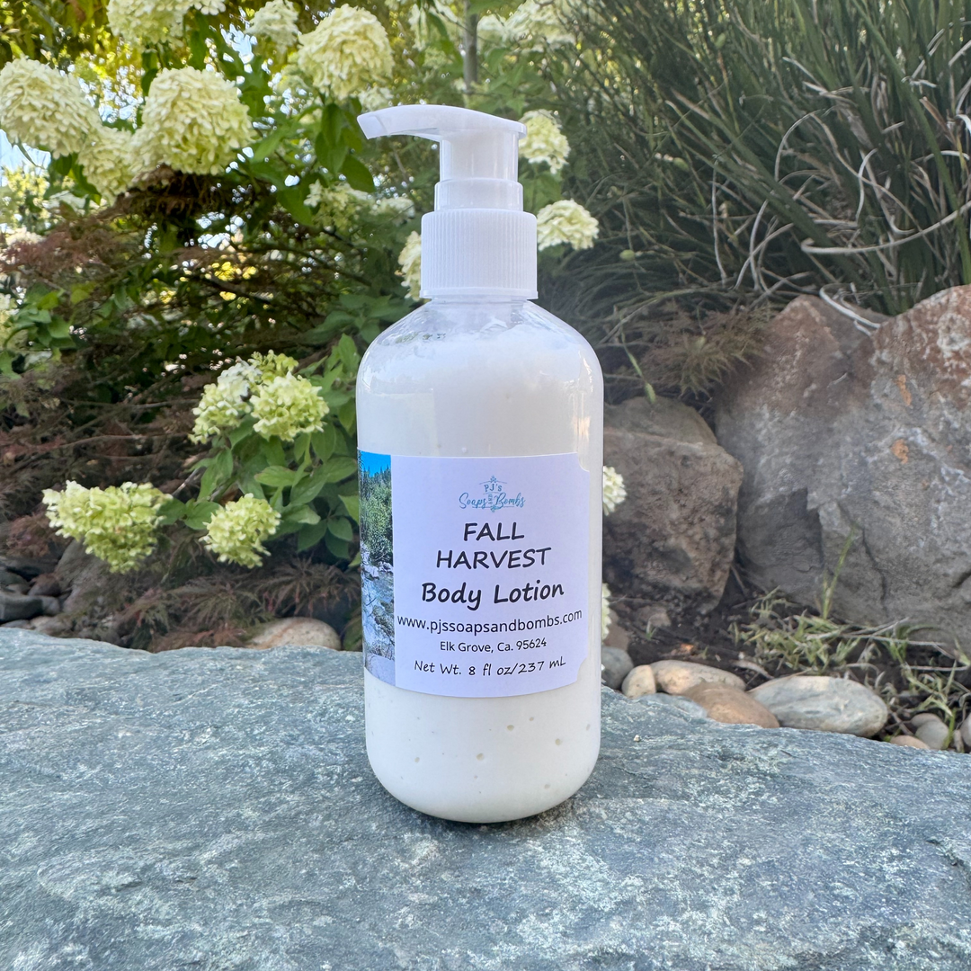 Body lotion bottle labeled 'Fall Harvest' on a stone surface with greenery in the background