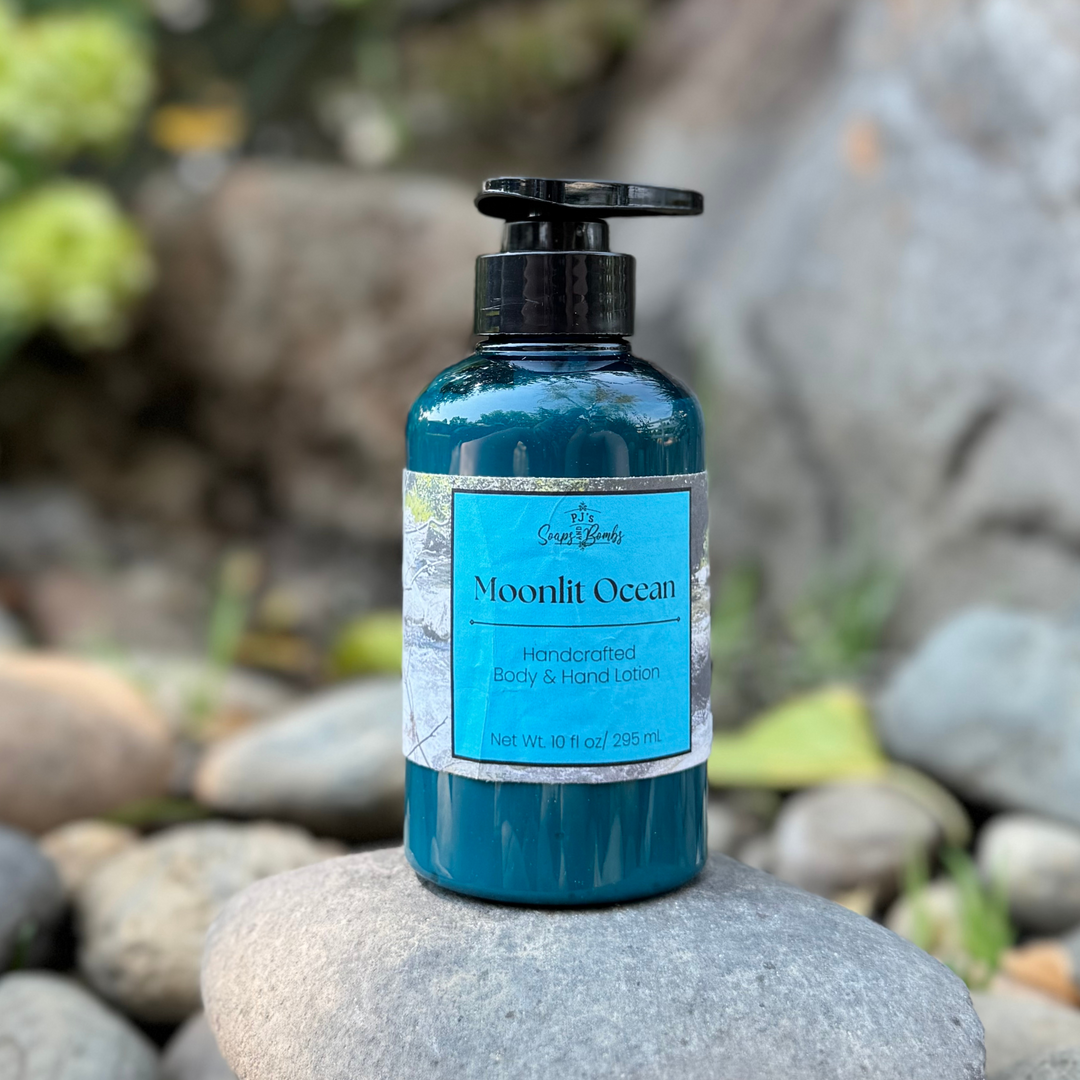 Blue bottle of 'Moonlit Ocean' body and hand lotion on a rock with a natural background