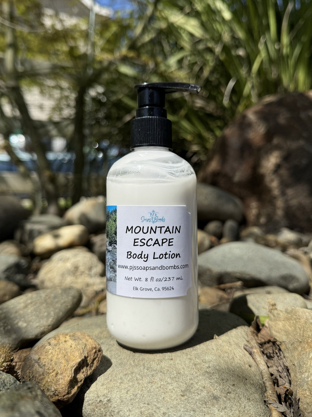 Mountain  Escape Body Lotion in natural setting sitting on a rock