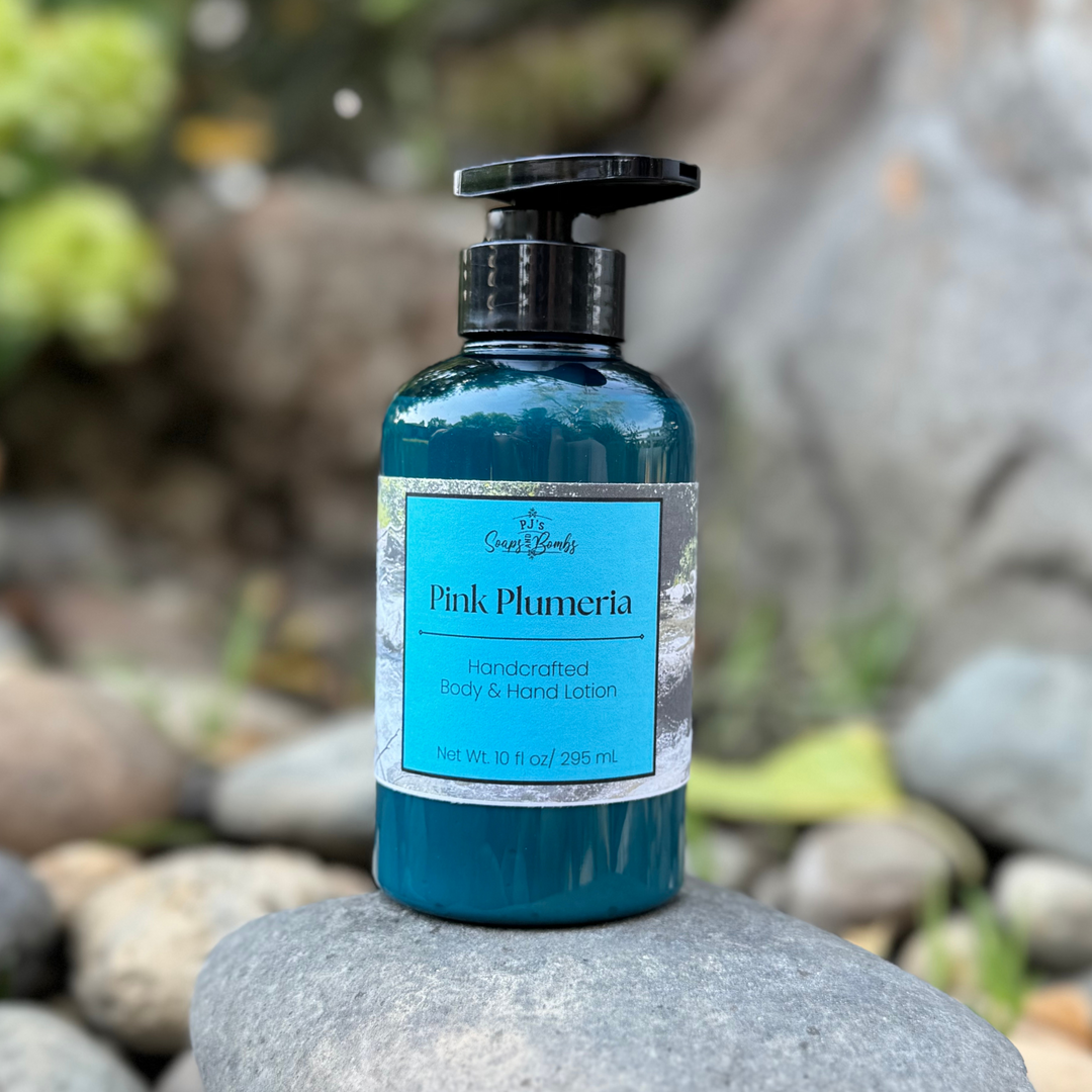 Blue lotion bottle labeled 'Pink Plumeria' on a rock with a natural background