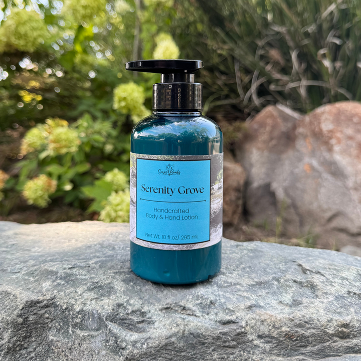 Blue bottle of Serenity Grove lotion on a rock with greenery in the background