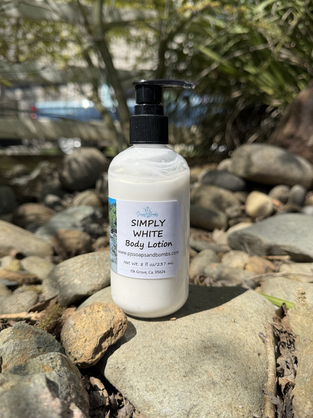 Simply White Body Lotion in natural setting sitting on a rock
