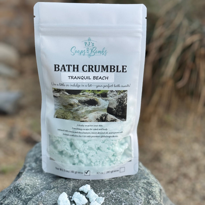 Bath crumble packaging labeled 'Tranquil Beach' on a stone surface with blurred natural background