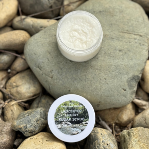 Unscented Luxury Fragrance Free Sugar Scrub in an open jar on a rock in a natural setting