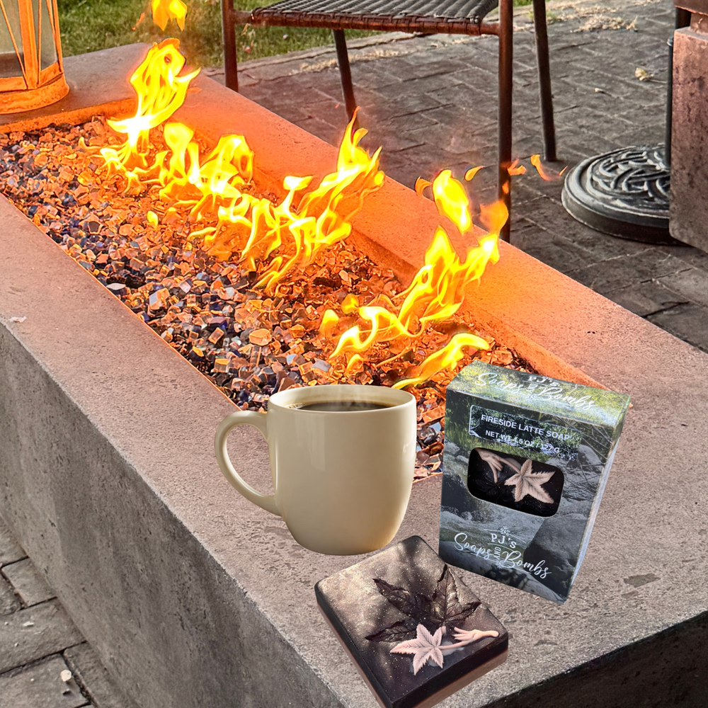 a soap siting on an outdoor fire pit with a boxed soap and cup of coffee next to it
