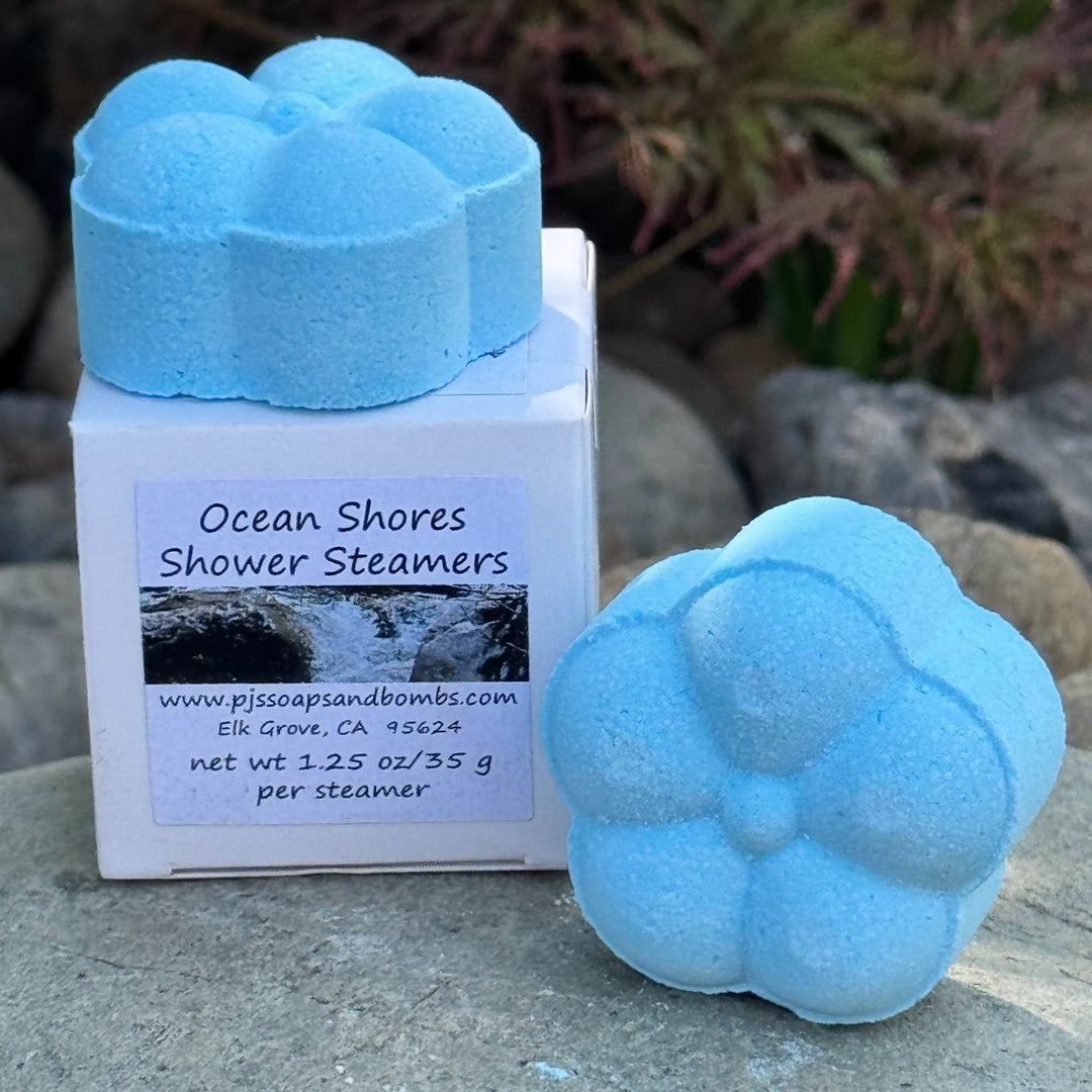 Ocean Shores Blue Shower Steamers with box in a natural setting on a rock